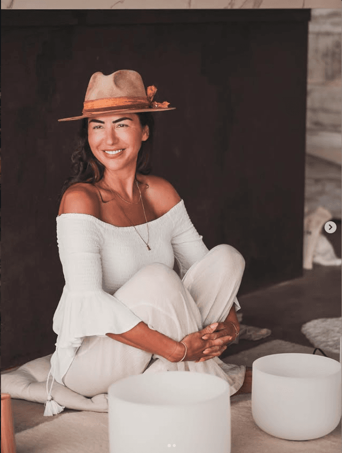 Tanya seated in white linen, smiling beside her crystal singing bowls